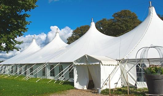 tall green portable restrooms assembled at a music festival, contributing to an organized and sanitary environment for guests in Westmoreland